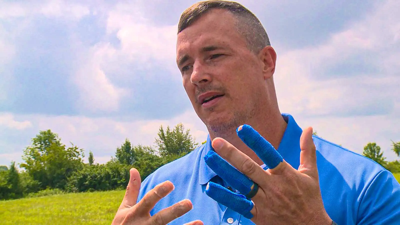 man with blue bandages on his fingers