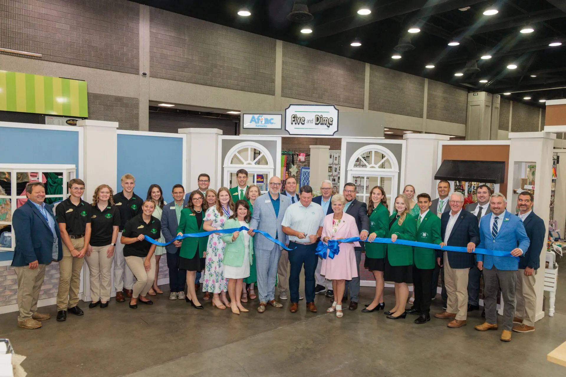 A large group of people cutting a ribbon in 4-H cloverville