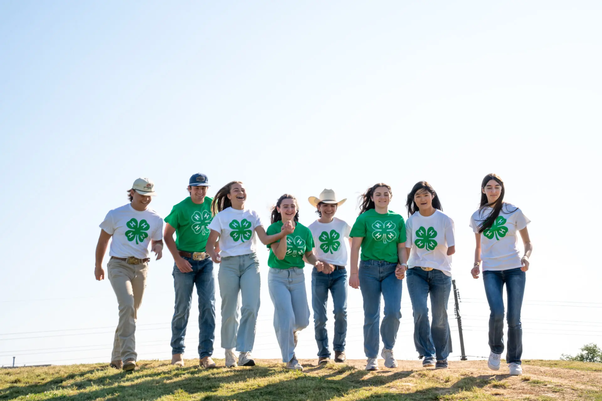 A group of 4-Hers running down a hill.